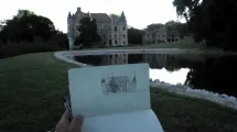 Le château au petit matin avec au 1er plan un carnet de dessin sur lequel il a été dessiné © Hervé Frumy