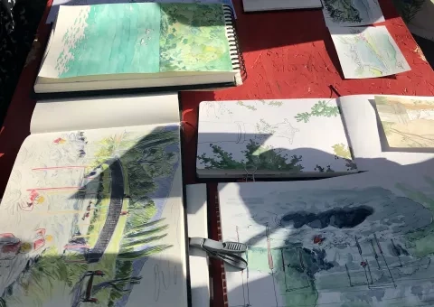 série de dessins (cartes, feuilles) sur une table improvisée à Quirieu © Département de l'Isère